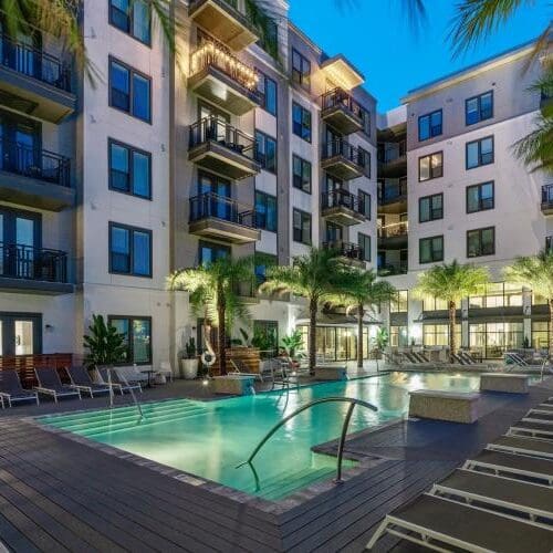 Twilight resort pool at NIKA's military furnished TDY apartments in Tampa.